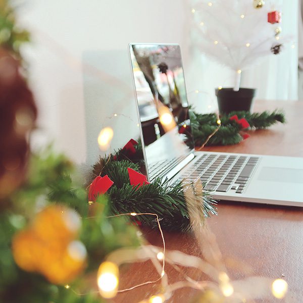 Laptop open on a desk decorated for Christmas