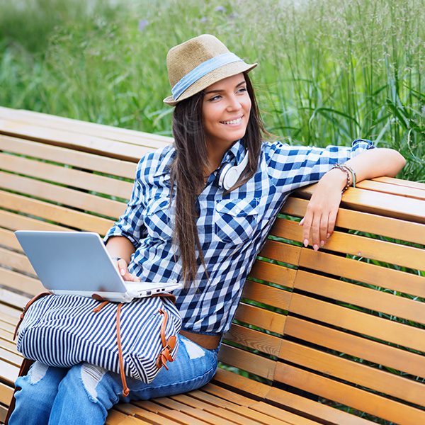 Woman on a bench with a laptop learning about PPC and SEO
