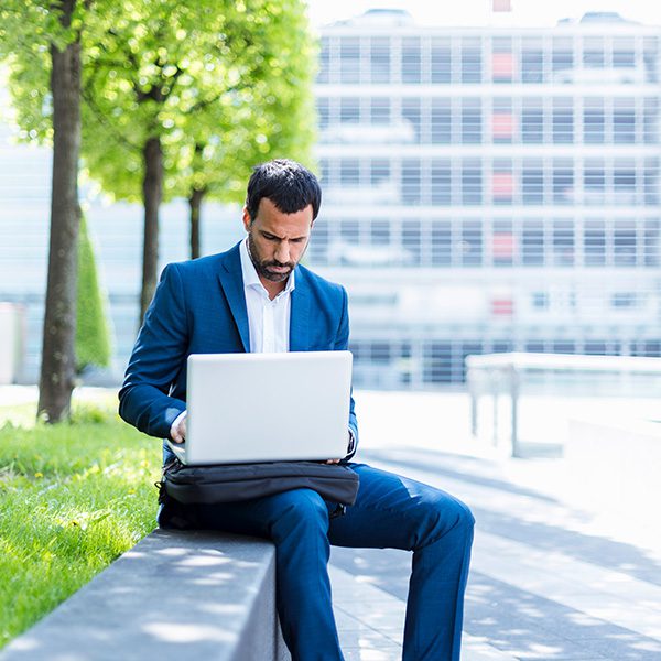 Man on a laptop looking at his company website.