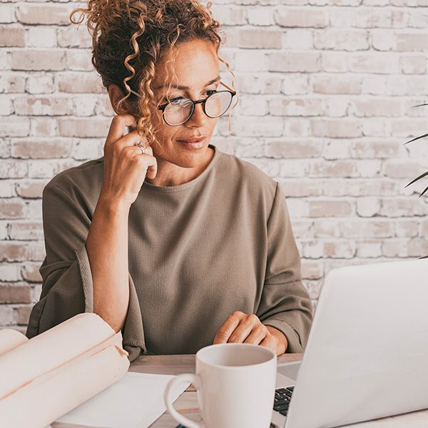 Woman at laptop learning how to embed video in WordPress