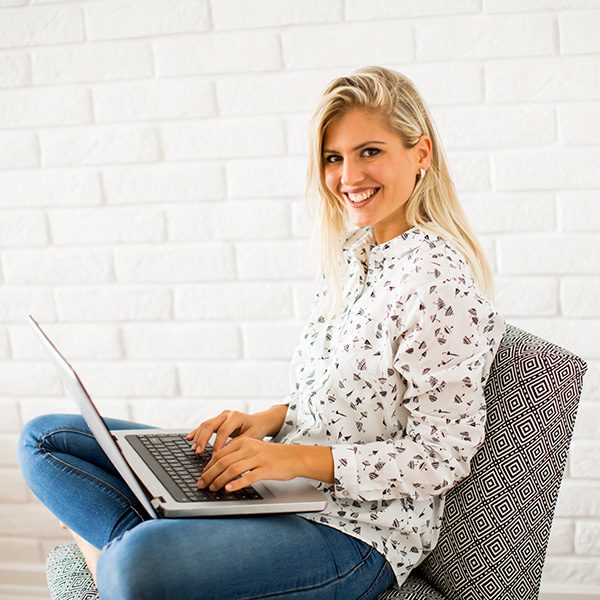 Woman at her computer smiling and learning about SEO copywriting services