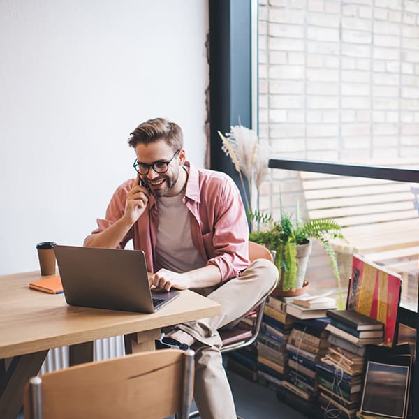 Happy guy on his laptop learning about web design and hosting