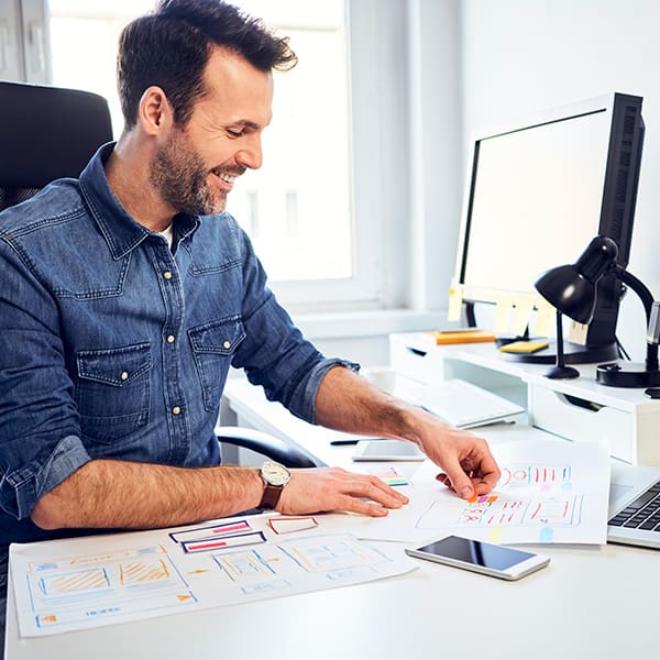 A man working at his desk thinking about how to choose a web design company