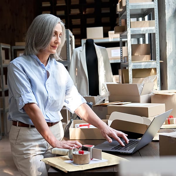 eCommerce owner on her laptop reading about Magento vs WooCommerce