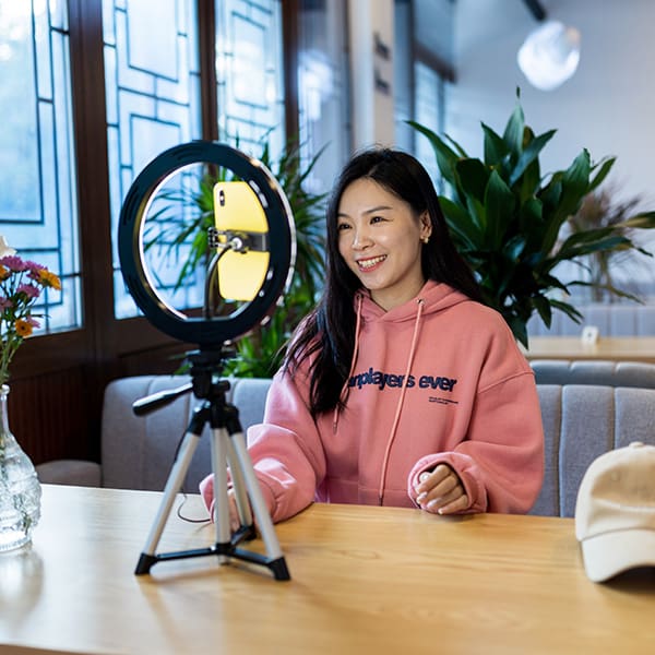 Woman on her phone making a tiktok promotion video