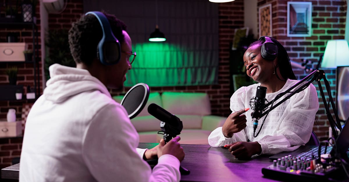 Everything You Need to Know About a Podcast Manager 2 Two people discuss the responsibilities of a podcast manager on their podcast show